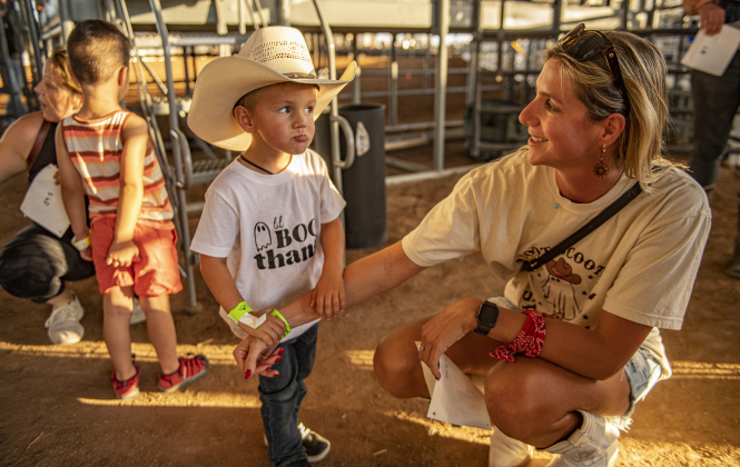 : 3-year-old Christopher McWhorter, with his his mom Kaitlin McWhorter, is ready to compete in Mutton Bustin' at the Williamson County Fair Rodeo  on Friday, October 25, 2024.    Photo by Andy Sharp