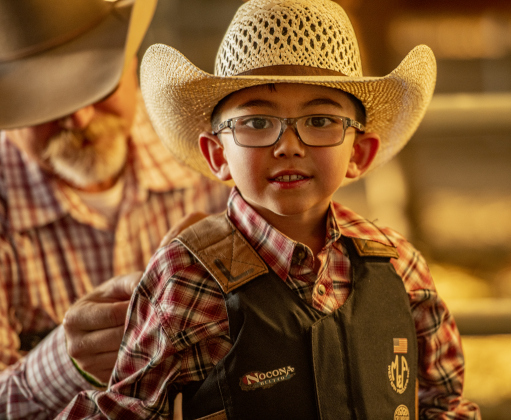 6-year-old Boone Reinke, with his father Troy Reinke, competed in Mutton Bustin' at the Williamson County Fair Rodeo  on Friday, October 25, 2024. Boone went on to win the competition.     Photo by Andy Sharp.