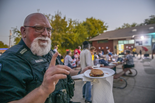 Georgetown police officer Shane Rogers enjoyed a grilled hamburger during a National Night Out event held on Tuesday, October 1, 2024 at the Georgetown Housing Authority Activity Learning Center on West 18th Street.    Photo by Andy Sharp. 