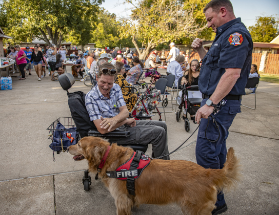 Shane Henry, left, visits with the Georgetown Fire Department's Deputy Fire Marshal Jonathan Gilliam and Koda, the fire department's fire dog during a National Night Out event held on Tuesday, October 1, 2024 at the Georgetown Housing Authority Activity Learning Center on West 18th Street.    Photo by Andy Sharp.