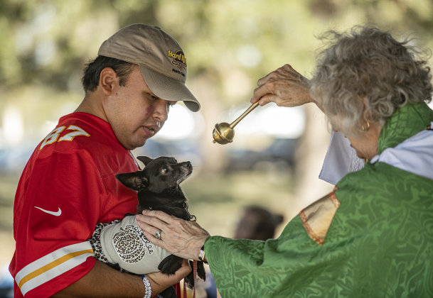 Pepper, with A.J. Cortez,  is bestowed a blessing by The Reverend Mary Ann Huston during the Grace Episcopal Church Blessing of the Animals service held at San Gabriel Park on Sunday, October 6, 2024.   Photo by Andy Sharp.