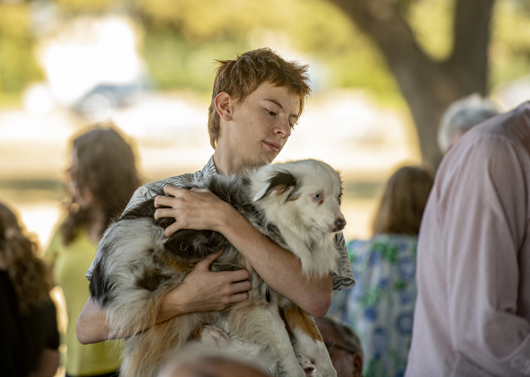 Sheila, with Zack Van Nostrand, 15, waits for her blessing to be bestowed by The Reverend Mary Ann Huston during the Grace Episcopal Church Blessing of the Animals service held at San Gabriel Park on Sunday, October 6, 2024.   Photo by Andy Sharp.