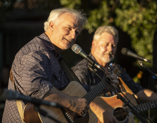 Ken Covington, left, performs with friend Bob Case  during a First Friday Concert held at Founders Park on Friday, October 4, 2024.  Covington, founder of Kenz Guitars,  suffered a stroke in September 2023.  He's been on the mend for the past year.  He was honored with a proclamation presented by Georgetown Mayor Josh Schroeder.   Photo by Andy Sharp.