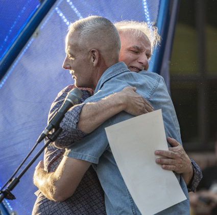 Ken Covington accepts congratulations from Georgetown Mayor Josh Schroeder during a First Friday Concert held at Founders Park on Friday, October 4, 2024.  Covington, founder of Kenz Guitars,  suffered a stroke in September 2023.  He's been on the mend for the past year.  He was honored with a proclamation presented by Schroeder.   Photo by Andy Sharp.