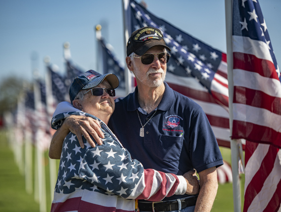Jim Watters, a Vietnam-era Air Force veteran, is joined by his wife Dianne as they post a flag honoring Jim's father, Jim Watters Sr., a World War II Navy veteran,  on Saturday, November 9, 2024, the official opening day of the Field of Honor.   Sponsored by the Rotary Club of Georgetown, the Field of Honor includes 2,000 American flags covering ten acres in San Gabriel Park.  With events throughout the week, the flags will fly here until November 17th.   Photo by Andy Sharp.
