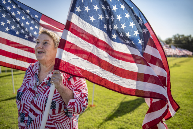 Mary Page prepares to post a flag honoring her late husband John Page, an Army veteran, on Saturday, November 9, 2024, the official opening day of the Field of Honor.   Sponsored by the Rotary Club of Georgetown, the Field of Honor includes 2,000 American flags covering ten acres in San Gabriel Park.  With events throughout the week, the flags will fly here until November 17th.   Photo by Andy Sharp.
