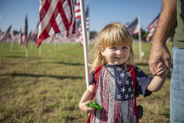 Two-and-a-half year-old Lupe Durran-Best joined his grandfather, Air Force veteran John Best as they posted a flag honoring John's late father, veteran William Best,  on Saturday, November 9, 2024, the official opening day of the Field of Honor.   Sponsored by the Rotary Club of Georgetown, the Field of Honor includes 2,000 American flags covering ten acres in San Gabriel Park.  With events throughout the week, the flags will fly here until November 17th.   Photo by Andy Sharp.