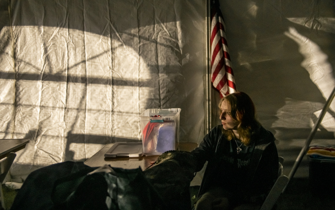 Elizabeth Fisher, 17, relaxes in the volunteer tent while waiting for her ride home   at the Georgetown Field of Honor on  Friday, November 8, 2024.  Sponsored by the Rotary Club of Georgetown, the Field of Honor includes 2,000 American flags covering ten acres in San Gabriel Park.  With events throughout the week, the flags will fly here until November  17th.   Photo by Andy Sharp.