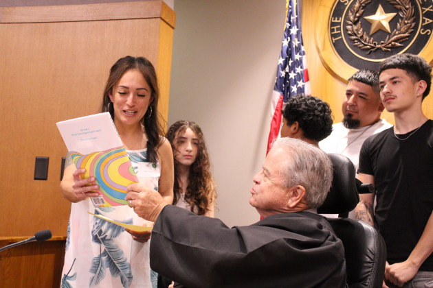Judge McMaster hands a copy of Dr. Seuss’s "Oh, the Places You'll Go!" to Ms. Stanley. Each family received a copy as a gift after the adoption.