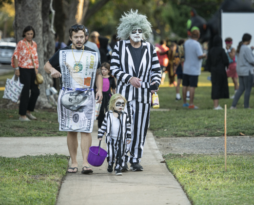 Tom Goebel, right, and his grandson Waylon Goebel, 3, were dressed as Beetlejuice, and joined by Tom's son (Waylon's dad) Zach Goebel, dressed as a $100 bill, during  Halloween night along Main Street  on Thursday, October 31, 2024.   Photo by Andy Sharp.
