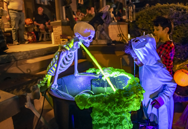 6-year-old Jelena Lake, , dressed as Lila from "Lilo and Stitch," was fascinated by a skeleton spewing water at a home  during  Halloween night along Main Street  on Thursday, October 31, 2024.   Photo by Andy Sharp.