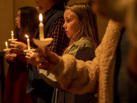 8-year-old Zinnia Crenshaw joins members of her family for the first of two candlelight services in Lois Perkins Chapel at Southwestern University, on Thursday, December 5, 2024. The annual Service of Lessons and Carols began in 1915, then called the Christmas Carol Service.   Photo by Andy Sharp. 
