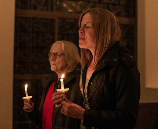 Traci McGrath, front, is joined by her mother-in-law Nancy McGrath during the first of two candlelight services in Lois Perkins Chapel  at Southwestern University, on Thursday, December 5, 2024.  Traci's husband (and Nancy's son) is Reverend Alan McGrath, pastor at Georgetown's First United Methodist Church.  The annual Service of Lessons and Carols began in 1915, then called the Christmas Carol Service.   Photo by Andy Sharp.