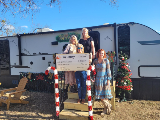 Fox Reality members Carla Gerlich, left, Renee Fox, top, and Deborah Everett, bottom, present a $30,000 check to Yesterday's Gone in front of the company’s donated camper, The Fox Den on December 17. Yesterday's Gone Executive Director Loree Tamayo, far right, gave them a tour of the camper. Photo by Nalani Nuylan.