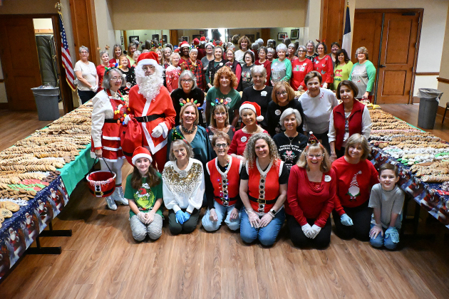 Women Helping Others volunteers in Sun City take time to pose for a group photo while preparing 500 dozen homemade cookies holiday distributions.