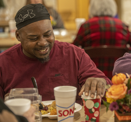 Gasius Keedricks enjoys a meal with friends during the Community Thanksgiving.