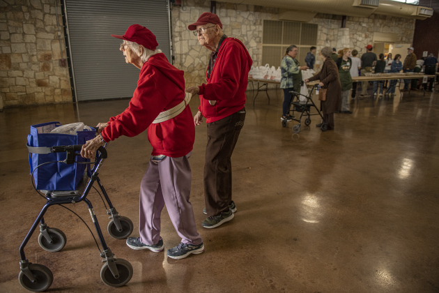 oana Ayers, 92, is assisted by her husband Jerry, 91, as they head for home after finishing their meals  during the Community Thanksgiving.