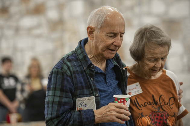 Ron Bean and Bonnie Oshel bow their heads during an opening prayer given by Rev. Dr. Roger Clayton, pastor at Georgetown's St. John's Methodist Church  during the Community Thanksgiving, held Thursday, November 28, 2024 at the San Gabriel Community Center in San Gabriel Park.