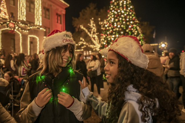Emiko Critchlow, 12, left, and her cousin Stella Green, 11, right, enjoyed spending time together at the annual Lighting of the Square in downtown Georgetown on  Friday, November 29, 2024. The streets and courthouse lawn were jammed with thousands of attendees on a cool autumn evening.    Photo by Andy Sharp.