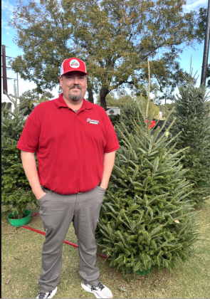 Aaron Brungot, who owns Brungot Farms in Cedar Park, stands in his Christmas tree lot at the Twin Lakes YMCA. His business supplied this year’s tree to the Governor’s Mansion.