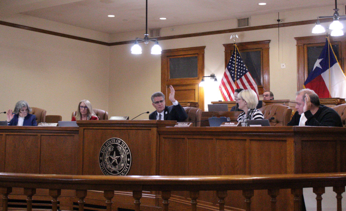 Commissioners Terry Cook, left, and Russ Boles, right, with County Judge Bill Gravell, center, vote in favor of adding another district court to Williamson County during the January 14 meeting. Photo by Nalani Nuylan.
