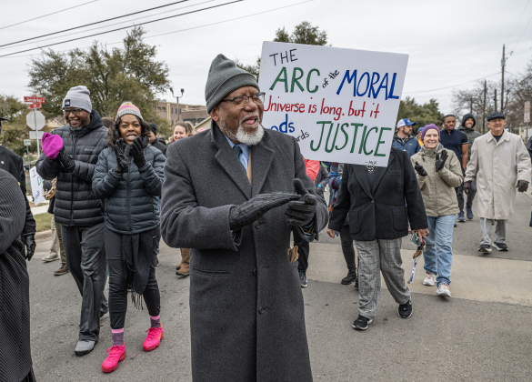 Dr. Ron Swain claps during the march along Martin Luther King Jr. Street.