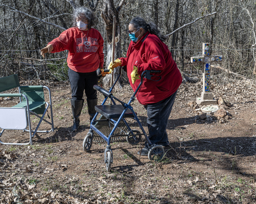 Teresa Shipley, left, and her aunt, Julia Garcia, right,  discuss  cleanup work  in an unnamed cemetery adjacent the Lawrence Chapel Cemetery on Saturday, January 18, 2025. The cross at right is the burial site of Jose Garcia.