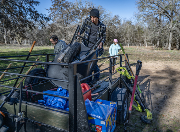 Thomas Arellano, front, his father Eric Arellano, back left, and family member Delores Moreno, back right, help with cleanup work  in an unnamed cemetery adjacent the Lawrence Chapel Cemetery on Saturday, January 18, 2025.