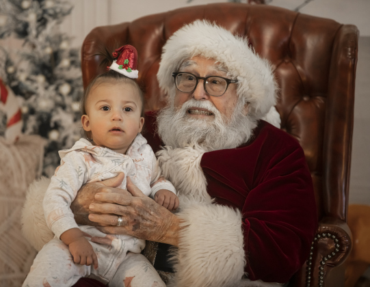 One-year-old Izzy Houchin visits with Santa Claus during  Breakfast With Santa, held Saturday, December 21, 2024 at the San Gabriel Community Center.  The event, coordinated by the Georgetown Fire Department and the Rotary Club of Sun City, served up pancakes, sausage, juice and coffee too attendees.  Santa Claus was there throughout the morning to visit the kids and their families.    Photo by Andy Sharp.
