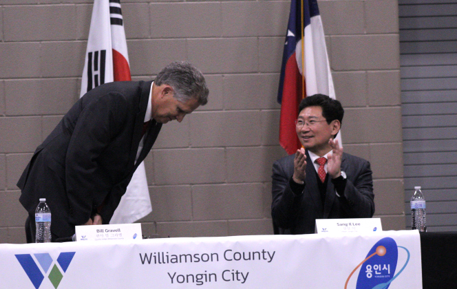 County Judge Bill Gravell bows in respect to Mayor Sang il Lee.