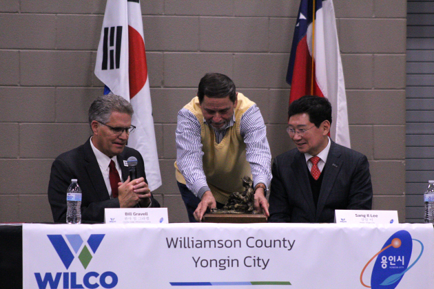 Dave Porter, executive director for Williamson County Economic Development Partnership, presents Mayor Lee with a cowboy statue as a gift from the county. The statue was made by a Wilco artist.