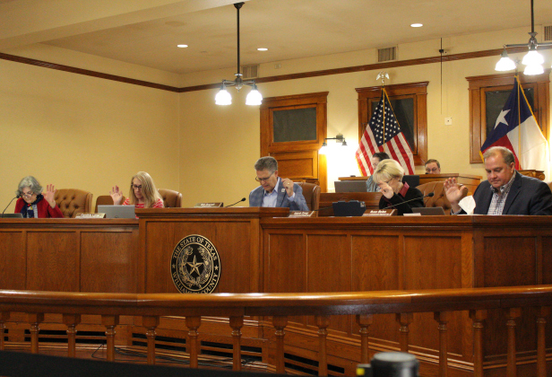Williamson County Commissioners Court, from left: Terry Cook, Cynthia Long, County Judge Bill Gravell, Valerie Covey and Russ Boles, vote to hire a law firm to pause the operations of the Cameron County Housing Finance Corporation, February 25. Photo by Nalani Nuylan.