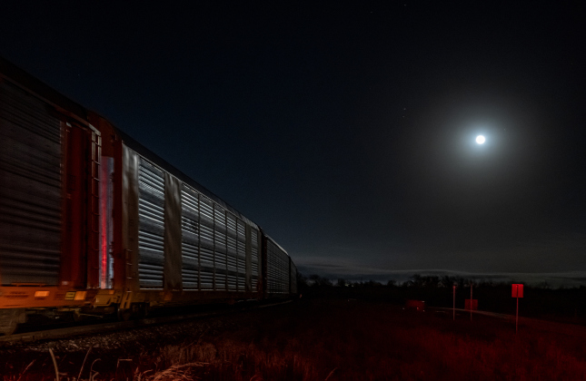 The Waning Gibbous moon, at 99.9% visibility, shines beyond a freight train passing County Road 401 on  Wednesday, February 12, 2025.