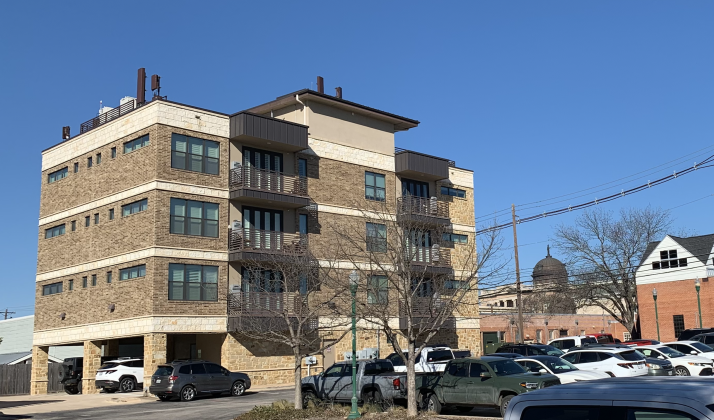 An apartment building located near the Georgetown Public Library is seen with the Williamson County courthouse in the background. If SB 840 passes, more multi-family buildings like this could appear downtown. (Photo by Kaitlyn Wilkes)