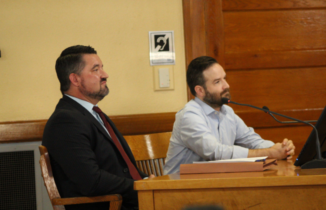 County Engineer Adam Boatright, front, and David Glenn, director of government relations with Home Builders Association, back, explain the new subdivision regulations during the March 4 Commissioners Court meeting. Photo by Nalani Nuylan.