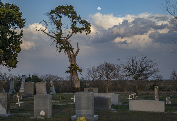 A Waxing Gibbous moon, at 98.9% visibility, shines over the cemetery at Zion Lutheran Church Sandoval along County Road 425 on Wednesday, March 12, 2025.     Photo by Andy Sharp.   