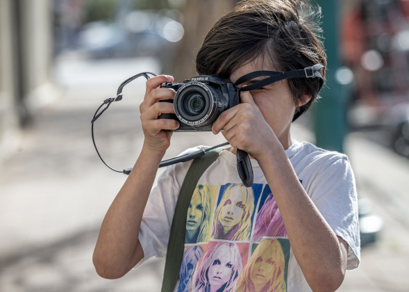 Nine-year-old Wyatt Rollins, joined by his dad, Jim Rollins, takes photographs along 8th Street during the Texas Photography Festival on Saturday, March 15, 2025.