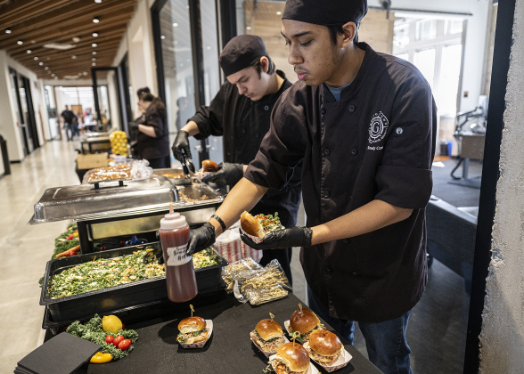 Culinary Arts students Kahless Fabricatore, front, and Jude Frintz, both East View High seniors, prepare pork sliders for attendees at the Georgetown I.S.D. State of the District event, held at district headquarters on Thursday, March 13, 2025.   Photo by Andy Sharp.