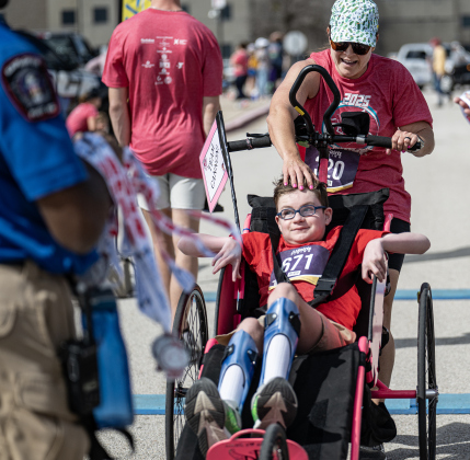 Ainsley’s Angels team member Cannon Collier is congratulated by Melody Lusk as they near the finish line of their 5K race during the 13th Annual Chase the Chief, held Sunday, March 2, 2025 at East View High School.   2,000 people were registered for the one-mile fun run and 5K event.   Proceeds from the races support physical education programs in Georgetown.   Photo by Andy Sharp.