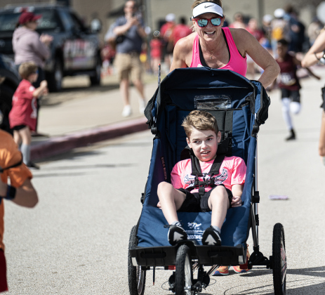 Ainsley’s Angels team member Conor Hamilton, 14, joined by his mom, Daphni Eissing, nears the 5K race finish line  during the 13th Annual Chase the Chief, held Sunday, March 2, 2025 at East View High School.   2,000 people were registered for the one-mile fun run and 5K event.   Proceeds from the races support physical education programs in Georgetown.   Photo by Andy Sharp.