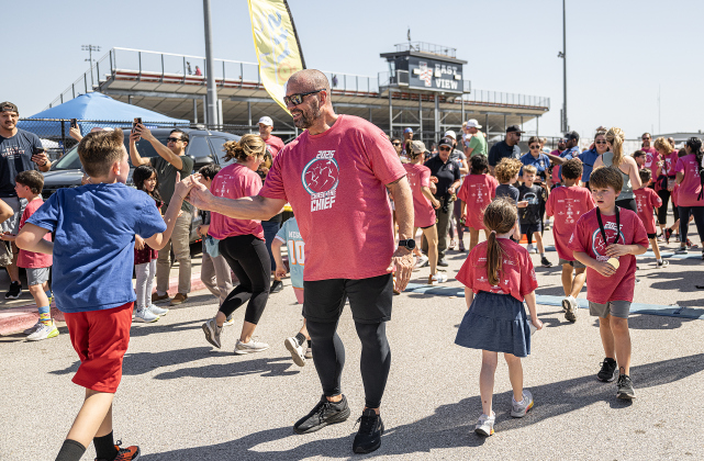 Georgetown Police Chief Cory Tchida  congratulates finishers in the one-mile Fun Run during the 13th Annual Chase the Chief, held Sunday, March 2, 2025 at East View High School.   2,000 people were registered for the one-mile fun run and 5K event.   Proceeds from the races support physical education programs in Georgetown.   Photo by Andy Sharp