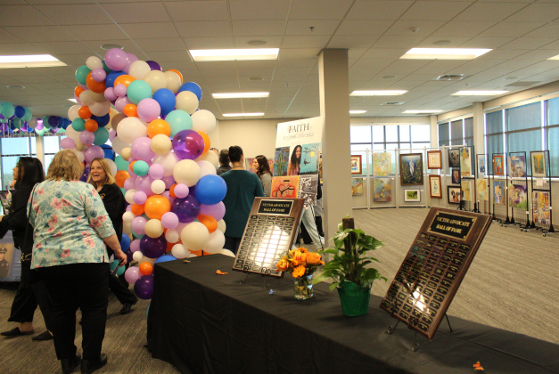 Attendees gather at the entrance of the National Crime Victims’ Rights Week Art Exhibit displayed at the Georgetown Annex, 100 Wilco Way, on April 9. Photo by Nalani Nuylan. 