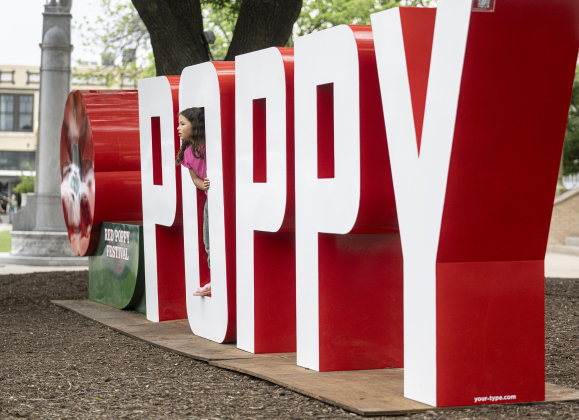7-year-old Leila Shalab enjoyed discovering the gigantic letters spelling “Poppy”  on the Williamson County Courthouse  lawn  on Saturday morning, April 19, 2025. The Red Poppy Festival comes to the Square this coming weekend.    Photo by Andy Sharp.  