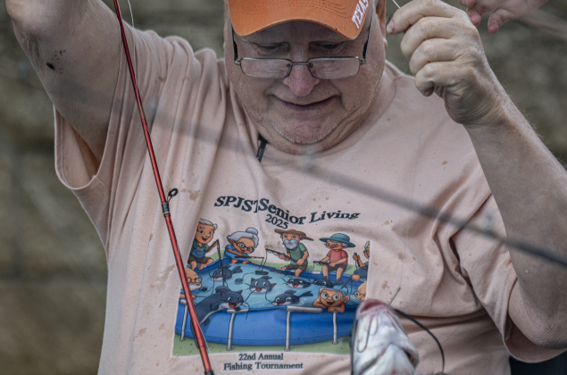 Tommy Sherek, 73, brings in a fish he caught  during the 22nd Annual Fishing Tournament held at Taylor’s SPJST Senior Living  on Thursday, April 24.