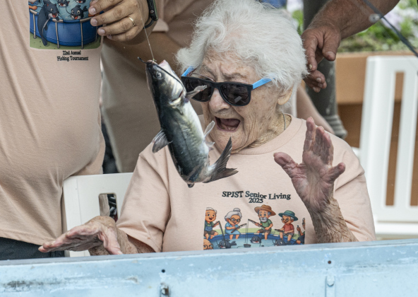 100-year-old Bertha Pistone reacts to a fish she caught during the 22nd Annual Fishing Tournament held at Taylor’s SPJST Senior Living  on Thursday, April 24, 2025.   A large tank was brought in, filled with water and loaded with 400 pounds of catfish.  Volunteers and staff were on hand to help with the fish as they were caught. The tournament continues Friday, culminating with a fish fry here at 6 p.m. Photo by Andy Sharp.