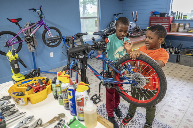 Nick Dan, 7, left, and his brother Noah, 5, enjoyed looking for bicycles  at Georgetown Free Bikes during the Grand Opening celebration of their new home on Saturday, April 5, 2025.