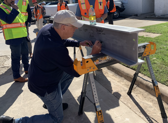 Community member Larry Olson, who provided resident input on the parking garage, signs a beam that will go inside the garage. Other members of city staff and developer Swinerton also signed. (Photos by Kaitlyn Wilkes)