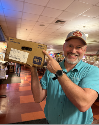 Chris Kerbow proudly wields a box of U.S. farm-raised catfish — which is antibiotic and hormone free.