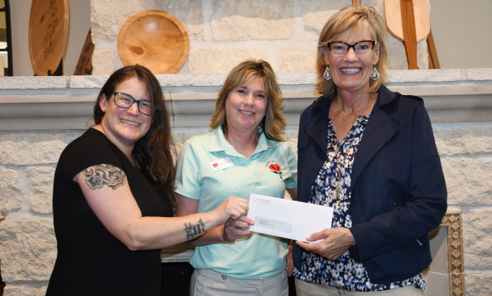  From left, A Gift of Time’s Community Educator Carolina Umana and Executive Director Becky Folta-May receive a WHO donation from WHO VP Judy Madsen.