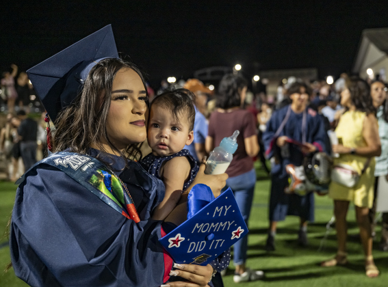 Graduating senior Hilda Ortega cuddles her 6-month-old daughter Leanna Roblez after commencement for East View High School at the Georgetown ISD Athletic Complex on Friday, May 23, 2025.  489 East View seniors received their diplomas.    Photo by Andy Sharp.